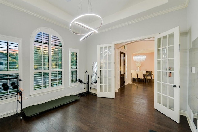 foyer featuring crown molding, a chandelier, french doors, and wood finished floors