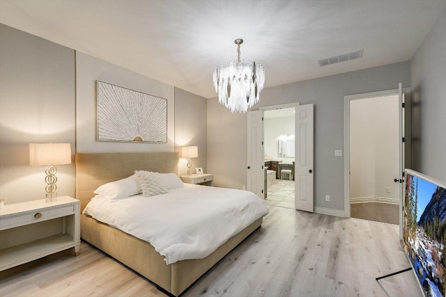bedroom with visible vents, wood finished floors, and an inviting chandelier