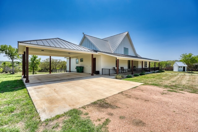 452 Sandy Cemetery Rd, Johnson City, TX 78636 - view of front of property with a shed, a standing seam roof, a front yard, concrete driveway, and an attached carport