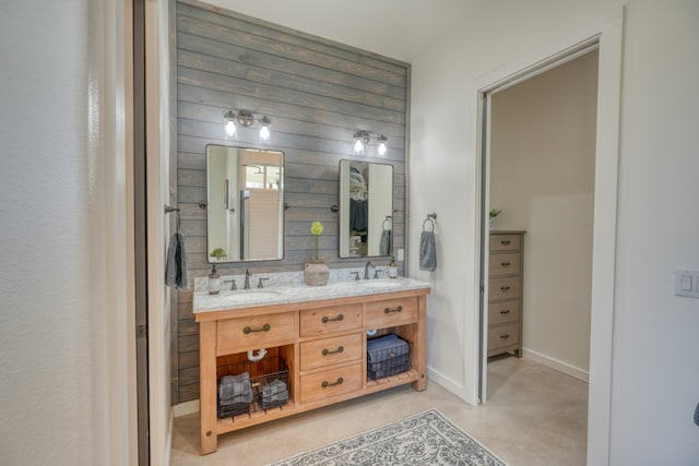 452 Sandy Cemetery Rd, Johnson City, TX 78636 - bathroom with a sink, double vanity, concrete floors, and wooden walls