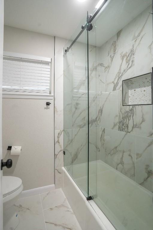 bathroom with toilet, marble finish floor, baseboards, and shower / bath combination with glass door