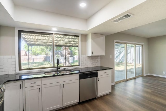 kitchen with dishwasher, dark wood-style flooring, a sink, and dark countertops