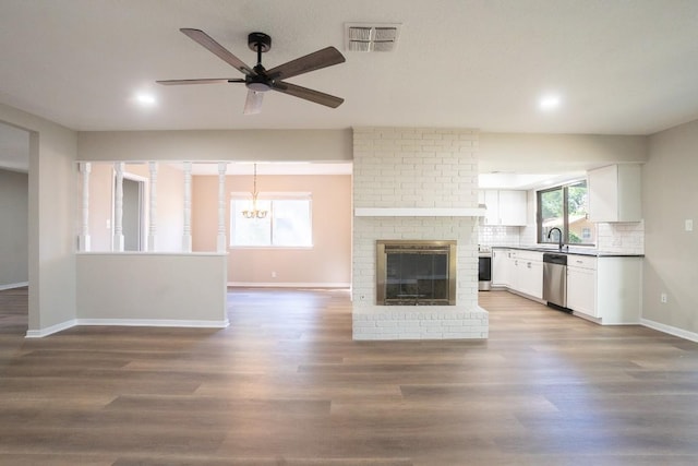 unfurnished living room featuring visible vents, baseboards, wood finished floors, and ceiling fan