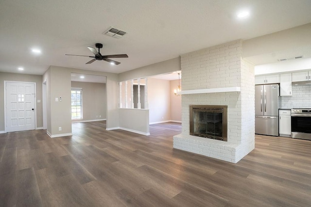 unfurnished living room with visible vents, baseboards, wood finished floors, and a fireplace