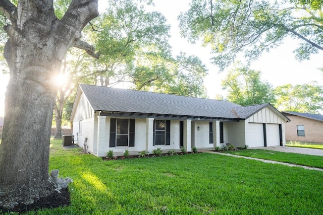 ranch-style home with roof with shingles, brick siding, an attached garage, and a front lawn
