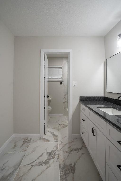 full bathroom with marble finish floor, vanity, and baseboards