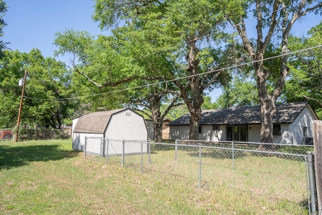 view of yard featuring a shed, fence, and an outbuilding