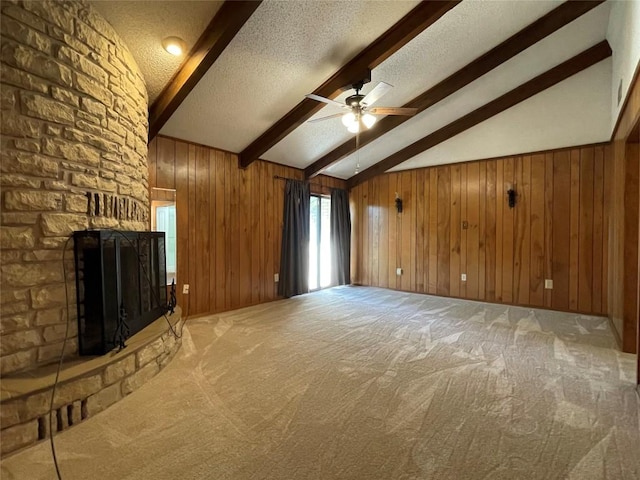 604 E Kerr St, Burnet, TX 78611 - unfurnished living room with a fireplace, ceiling fan, carpet, a textured ceiling, and wooden walls
