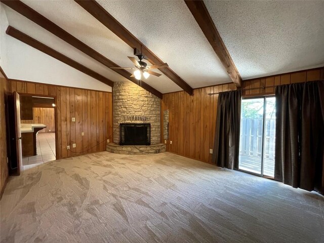 604 E Kerr St, Burnet, TX 78611 - unfurnished living room featuring a textured ceiling, ceiling fan, wood walls, light colored carpet, and a fireplace