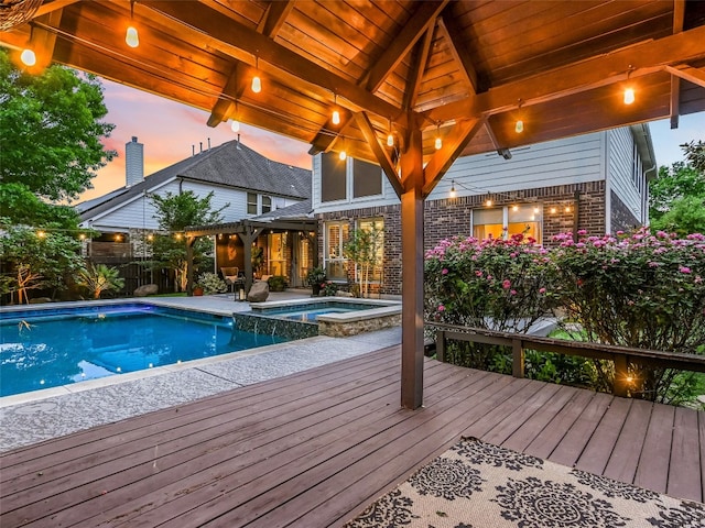 pool at dusk featuring fence, a gazebo, a pool with connected hot tub, and a patio