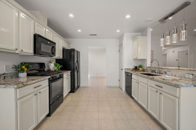 510 Sunny Brook Dr, Leander, TX 78641 - kitchen featuring black appliances, a peninsula, recessed lighting, light tile patterned floors, and light stone countertops