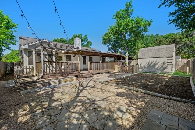 510 Sunny Brook Dr, Leander, TX 78641 - rear view of house featuring a fenced backyard, a chimney, a pergola, a storage unit, and a wooden deck