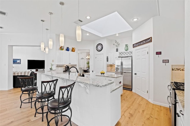 4010 Halfway Cv, Round Rock, TX 78681 - kitchen with light wood-style floors, a peninsula, visible vents, stainless steel appliances, and baseboards