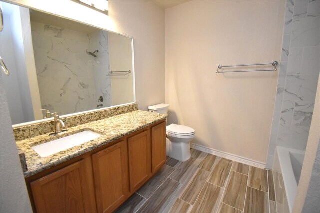 2305 Love Rd, Killeen, TX 76542 - bathroom featuring vanity, toilet, baseboards, wood finish floors, and bathing tub / shower combination