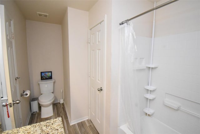 2305 Love Rd, Killeen, TX 76542 - bathroom featuring wood finished floors, toilet, shower / bath combo, and baseboards