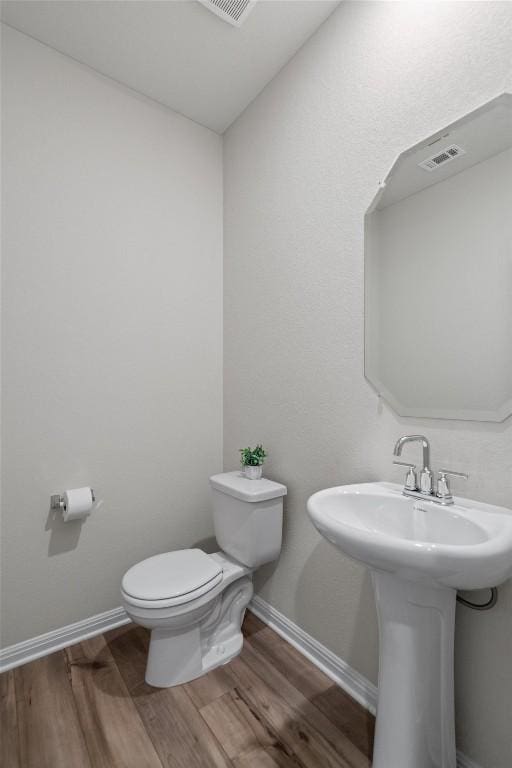 506 Windy Reed Rd, Hutto, TX 78634 - half bathroom featuring toilet and wood finished floors