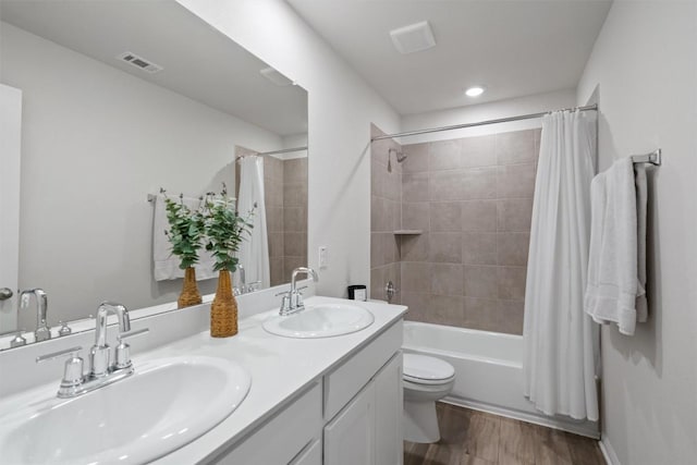 506 Windy Reed Rd, Hutto, TX 78634 - bathroom featuring double vanity, shower / bathtub combination with curtain, wood finished floors, and recessed lighting
