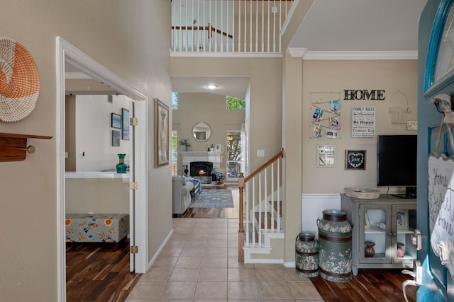 20300 Wayzata Ct, Pflugerville, TX 78660 - foyer with ornamental molding, stairs, wood finished floors, and a lit fireplace