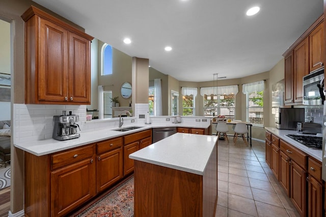 20300 Wayzata Ct, Pflugerville, TX 78660 - kitchen featuring appliances with stainless steel finishes, decorative backsplash, light countertops, brown cabinets, and recessed lighting