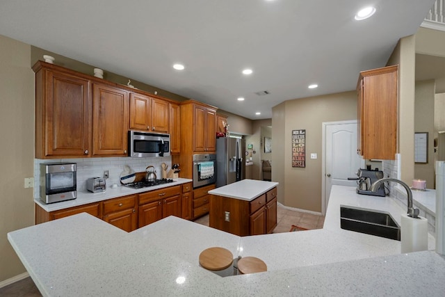 20300 Wayzata Ct, Pflugerville, TX 78660 - kitchen with stainless steel appliances, a center island, decorative backsplash, brown cabinetry, and recessed lighting