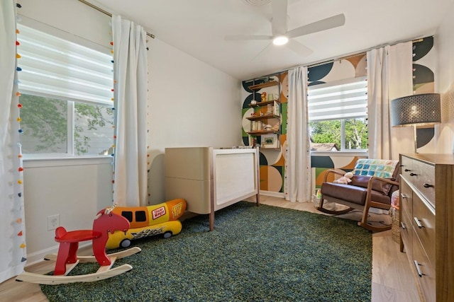 playroom with baseboards, a ceiling fan, and wood finished floors