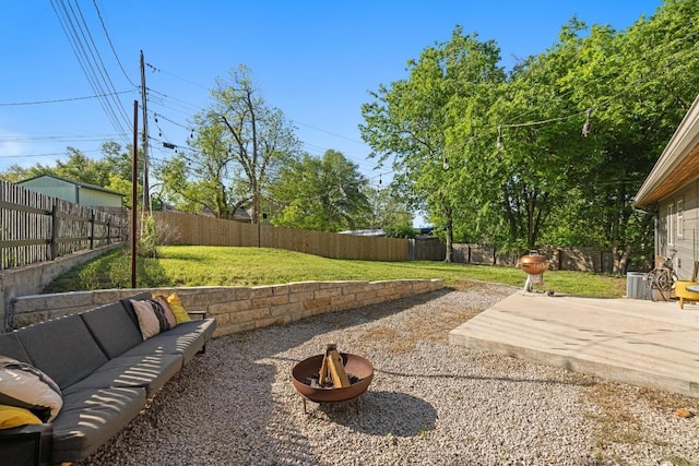 view of yard featuring a patio area, a fenced backyard, and an outdoor living space with a fire pit