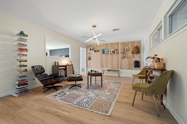 living area featuring visible vents, baseboards, and wood finished floors