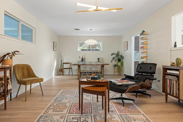 sitting room featuring baseboards and light wood finished floors