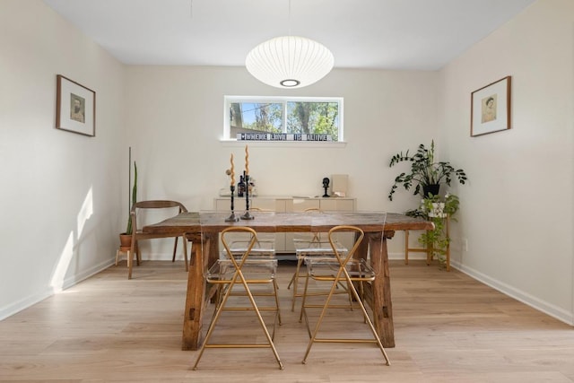 dining room with baseboards and light wood finished floors