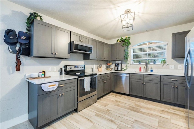 531 Wind Murmur, New Braunfels, TX 78130 - kitchen featuring light countertops, a sink, gray cabinetry, and stainless steel appliances
