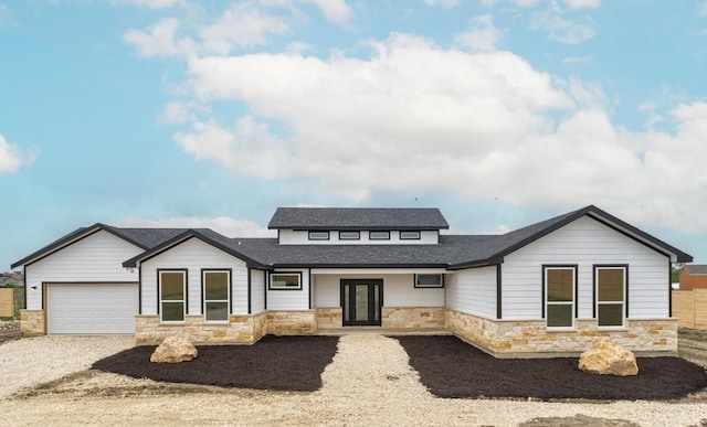 459 Rancho Linda Dr, Lockhart, TX 78644 - view of front facade featuring a garage, driveway, french doors, and stone siding