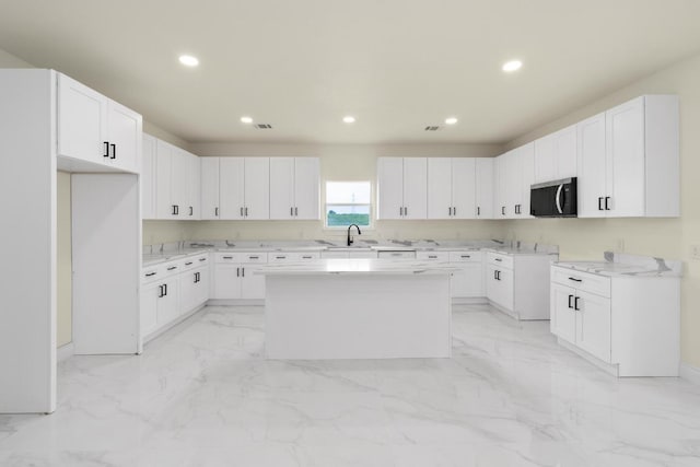 459 Rancho Linda Dr, Lockhart, TX 78644 - kitchen with a center island, stainless steel microwave, recessed lighting, and marble finish floor