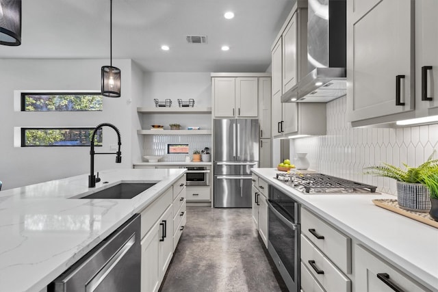 608B W 15th St, Georgetown, TX 78626 - kitchen featuring appliances with stainless steel finishes, wall chimney range hood, a sink, tasteful backsplash, and concrete floors