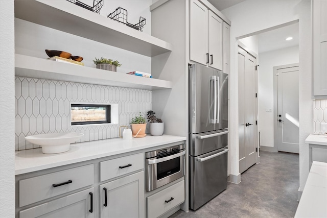 608B W 15th St, Georgetown, TX 78626 - kitchen with stainless steel appliances, open shelves, concrete floors, light countertops, and backsplash