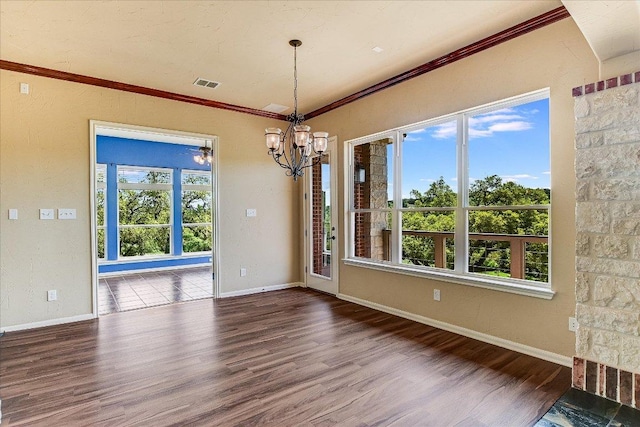 unfurnished dining area featuring baseboards, ornamental molding, a chandelier, visible vents, and wood finished floors