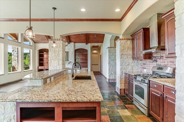 kitchen with gas range, a sink, wall chimney range hood, crown molding, and light stone countertops