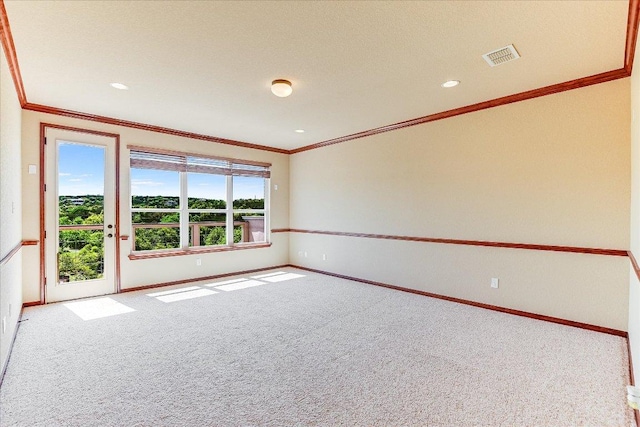 empty room featuring visible vents, baseboards, crown molding, and carpet floors