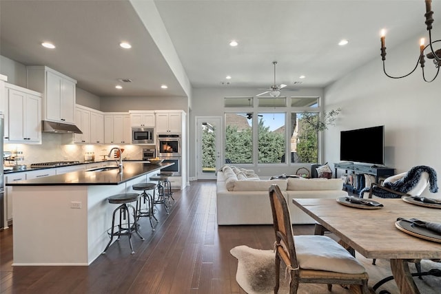 234 Sumalt Gap Way, Lakeway, TX 78738 - kitchen featuring stainless steel appliances, under cabinet range hood, dark countertops, open floor plan, and recessed lighting