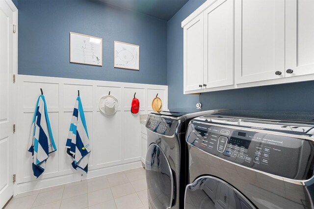 234 Sumalt Gap Way, Lakeway, TX 78738 - laundry room featuring washing machine and clothes dryer, cabinet space, a decorative wall, and light tile patterned floors