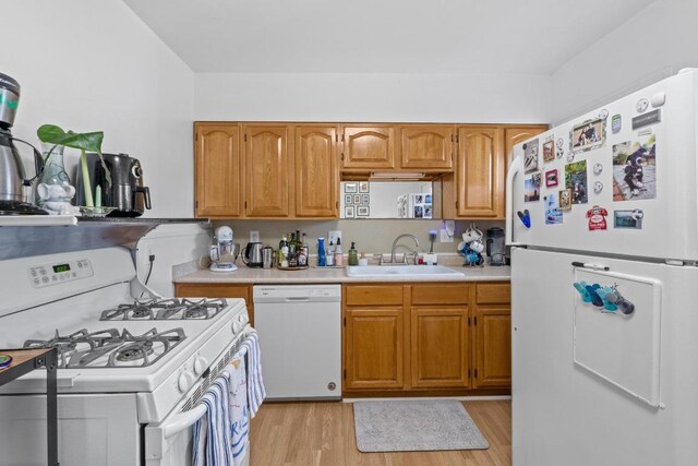 5708 Ave F, Austin, TX 78752 - kitchen with white appliances, light countertops, light wood-style flooring, and brown cabinetry