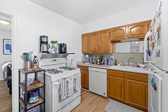 5708 Ave F, Austin, TX 78752 - kitchen with white appliances, light wood-type flooring, light countertops, and brown cabinets