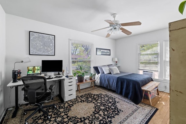 5708 Ave F, Austin, TX 78752 - bedroom with multiple windows, wood finished floors, a desk, and a ceiling fan