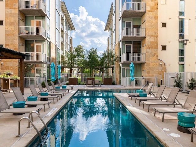 community pool featuring fence and a patio