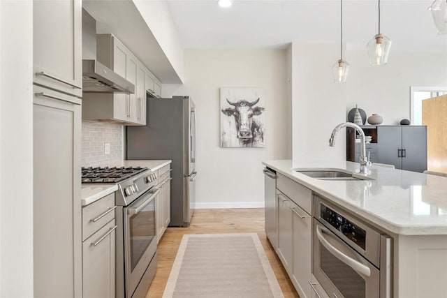 1600 Barton Springs Rd Unit 5503, Austin, TX 78704 - kitchen with stainless steel appliances, wall chimney exhaust hood, light wood-style flooring, backsplash, and a kitchen island with sink