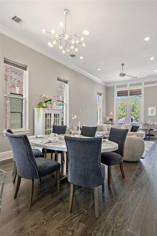 1015 Juniper St, Austin, TX 78702 - dining space featuring crown molding, visible vents, a chandelier, dark wood-style flooring, and recessed lighting