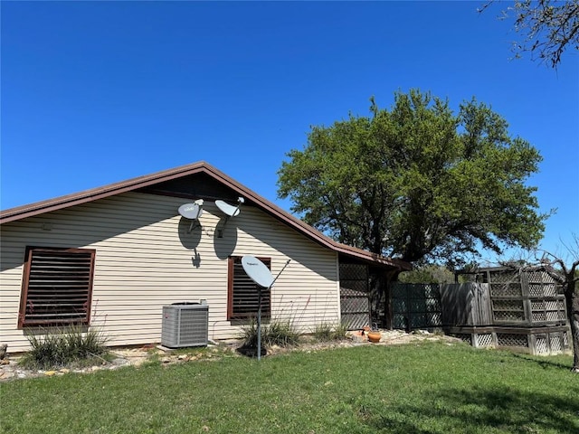 view of side of home featuring central air condition unit and a lawn