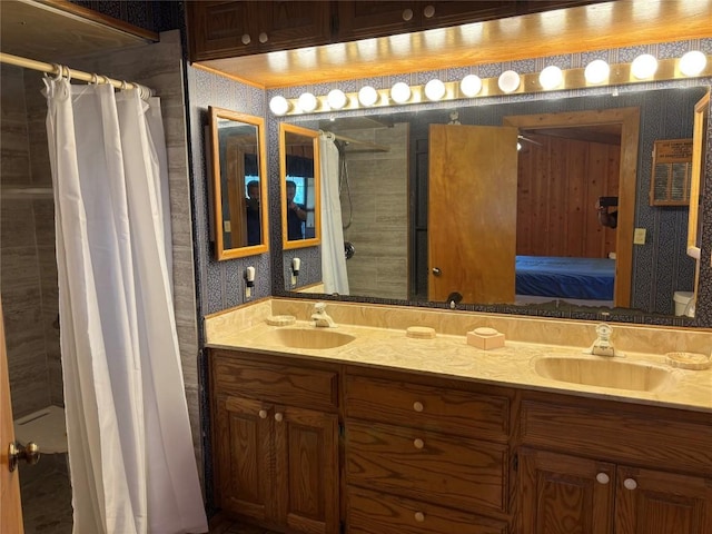 full bath with a sink, ensuite bathroom, double vanity, and tiled shower
