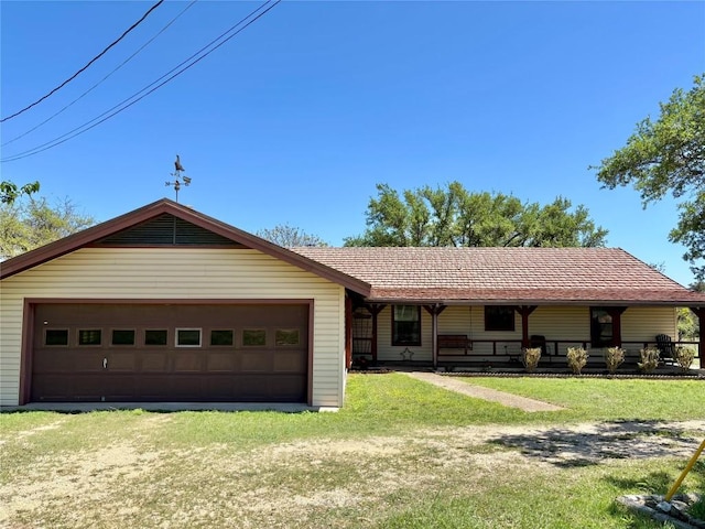 single story home with a front lawn, an attached garage, and covered porch