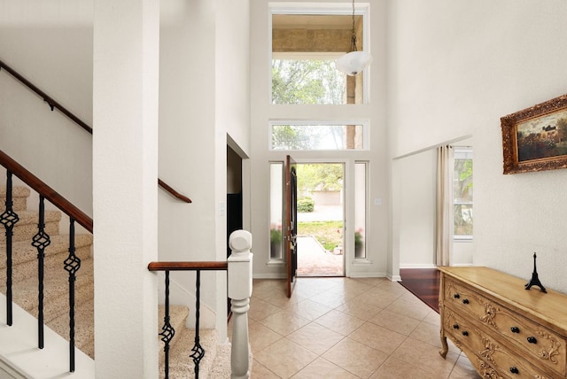 12528 E Labrador Cv, Austin, TX 78729 - foyer entrance with a high ceiling, light tile patterned floors, healthy amount of natural light, and stairs