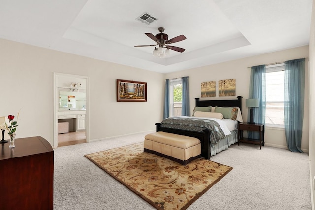 12528 E Labrador Cv, Austin, TX 78729 - bedroom with carpet, a tray ceiling, ensuite bathroom, and a ceiling fan